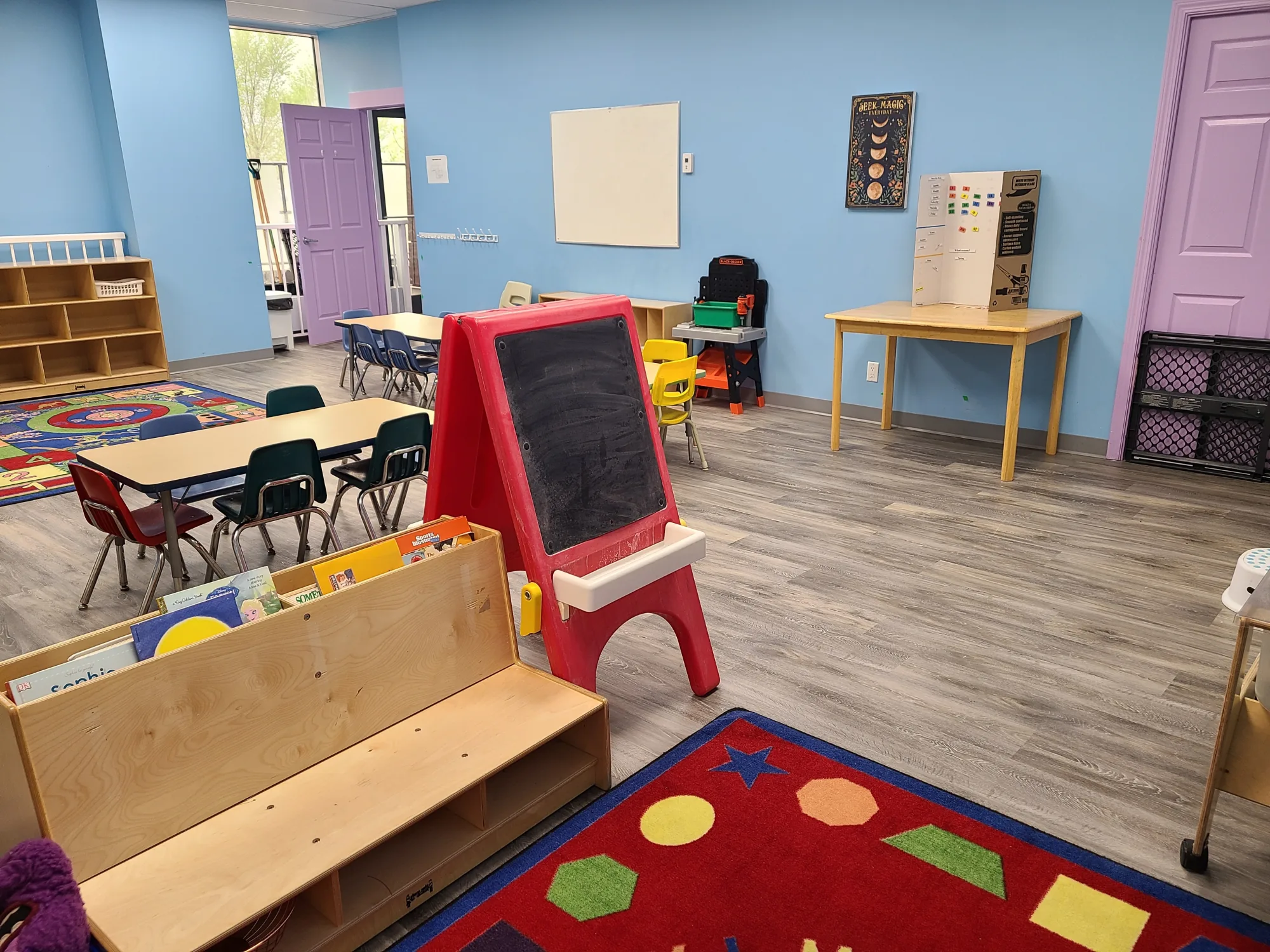 Village Scholars Preschool photo: open classroom zone with easel and rug