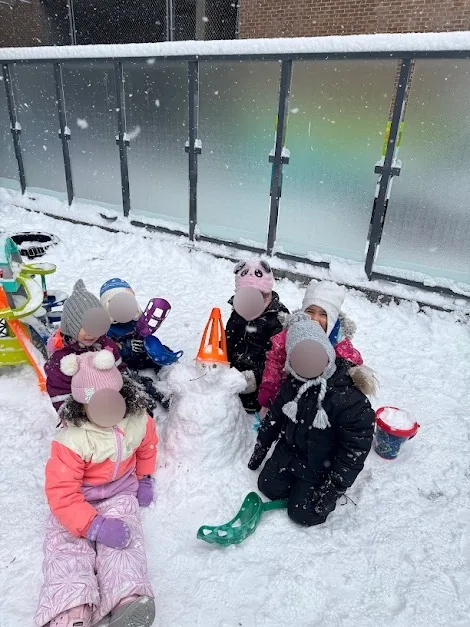 Village Scholars Preschool photo: group snow play in the fenced playground